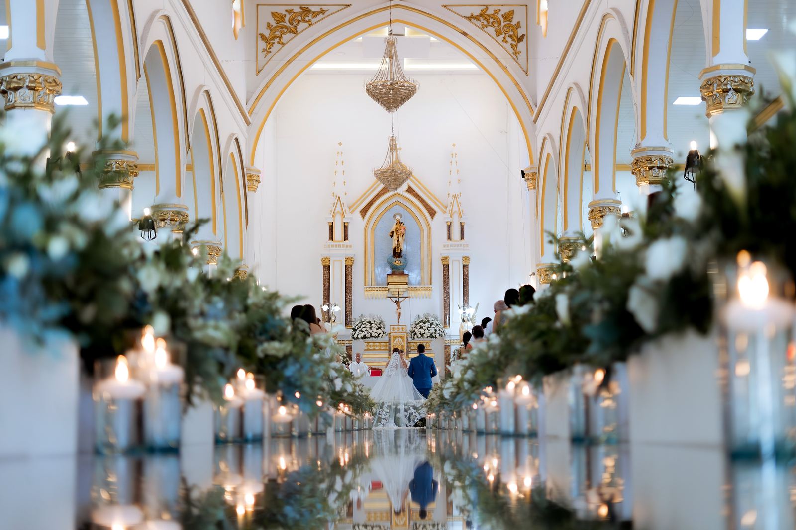 Ceremonia en una iglesia con pasillo de espejo y velas